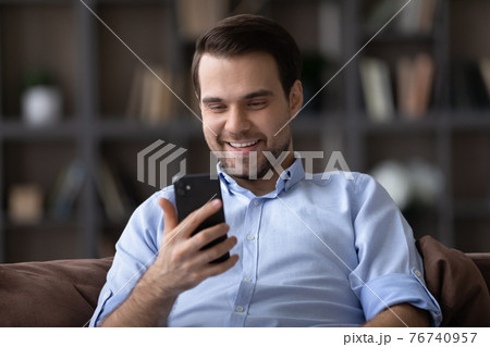 Smiling man relax at home using cellphone gadget 76740957