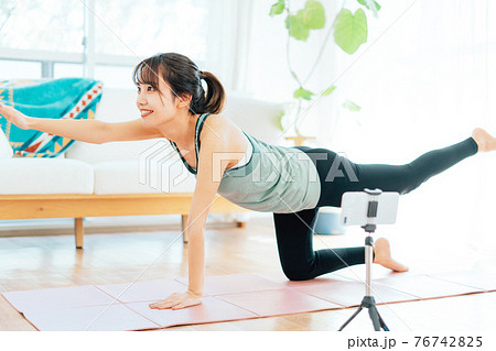 オンラインでヨガをする若い女性 76742825