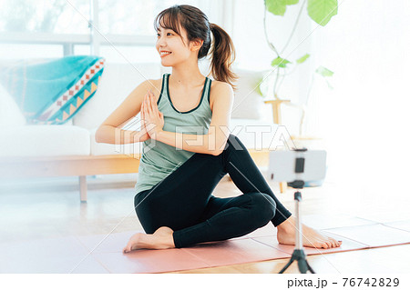 オンラインでヨガをする若い女性 オンラインでヨガをする若い女性 76742829