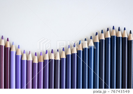Many shades of blue and purple pencils lying on white background closeup 76743549