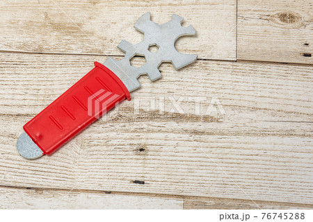 Construction tools on a wood background. Red handle. Lightweight new technology tools. 76745288
