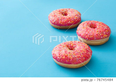 Pink frosted donut with colorful sprinkles Pink frosted donut with colorful sprinkles 76745484