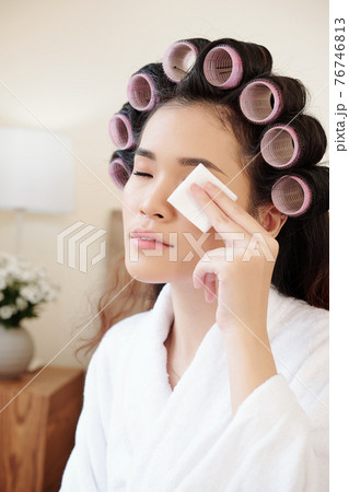 Woman removing eye make-up 76746813