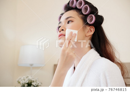 Young woman removing make-up 76746815