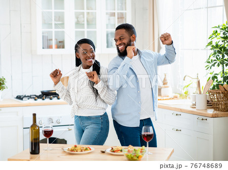 Home Date. Joyful Black Couple Dancing In Kitchen After Romantic Lunch 76748689