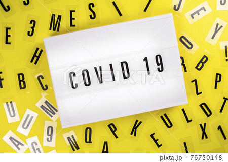 Lightbox with text COVID 19 on yellow background with letters, coronavirus news 76750148