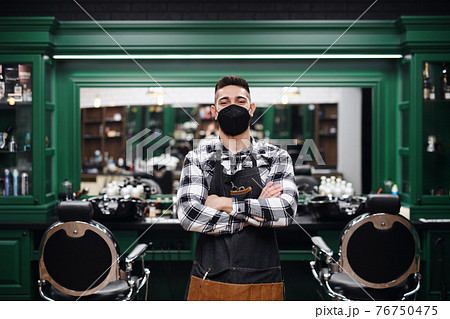 Young man haidresser in barber shop, coronavirus and new normal concept. 76750475