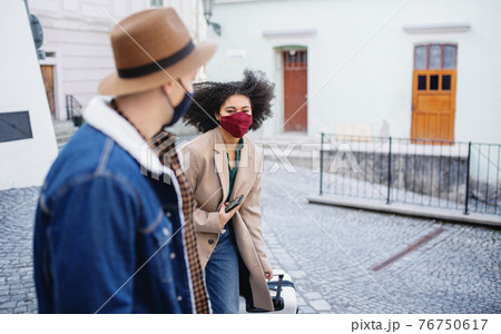 Young couple tourists with luggage walking on streets in old town, coronavirus concept. 76750617
