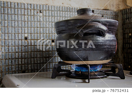 古い台所のガスコンロで土鍋料理をしている　 76752431