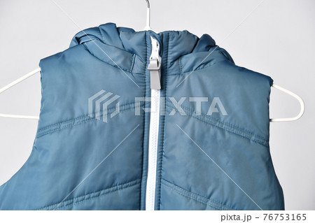 Trendy blue sleeveless vest on hanger in human Trendy blue sleeveless vest on hanger in human 76753165