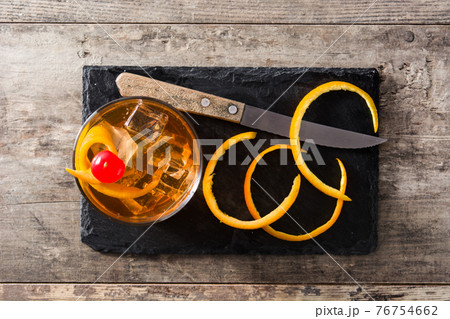 Old fashioned cocktail with orange and cherry 76754662