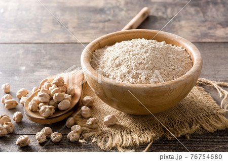 Chickpea flour in wooden bowl on wooden table 76754680