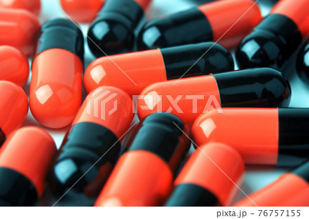 Red and black medicine capsules. 76757155