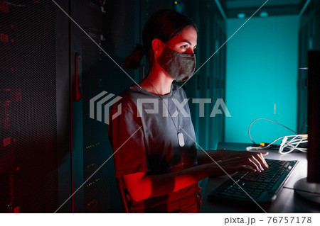 Female Network Engineer Wearing Mask in Data Center 76757178