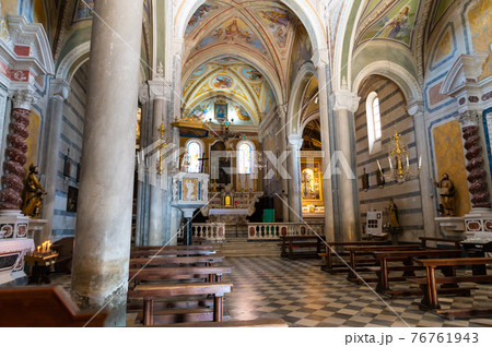 Corniglia, Liguria, Italy. June 2020. The interior of the church of San Pietro. From the windows the rays of the sun enter to illuminate the central nave. Corniglia, Liguria, Italy. June 2020. The interior of the church of San Pietro. From the windows the rays of the sun enter to illuminate the central nave. 76761943