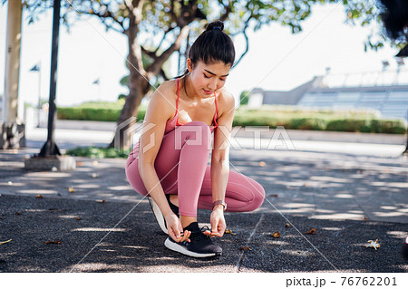 Woman tying shoelace while running 76762201