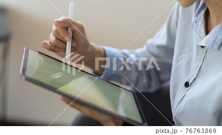 Close up view of female working on her project with digital tablet Close up view of female working on her project with digital tablet 76763869