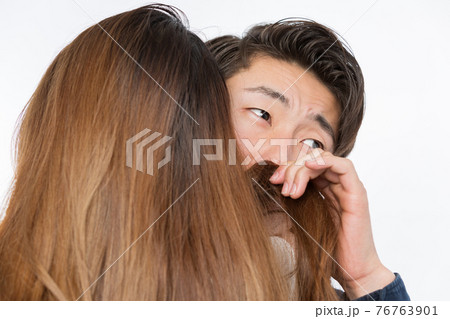 女性の髪を嗅ぐ男性 76763901