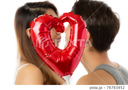ハート越しにキスするカップル ハート越しにキスするカップル 76763952