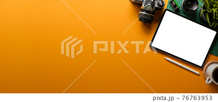 Yellow creative flat lay workspace with digital tablet, camera, lens, plan pot and copy space 76763953