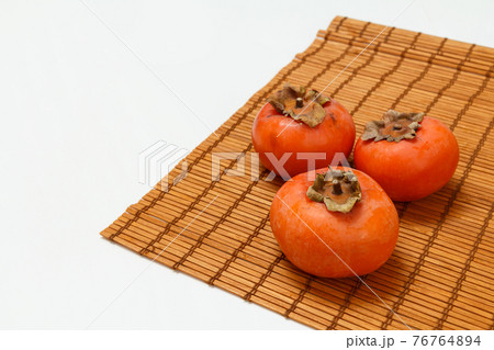 Ripe fresh persimmon fruits on bamboo napkin. 76764894