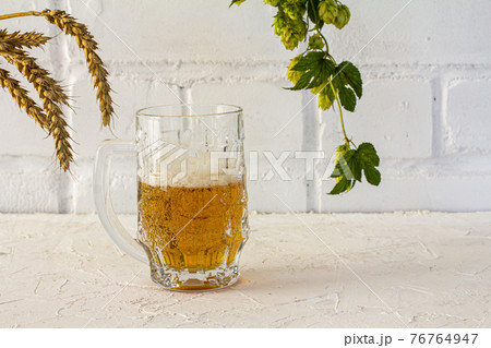 Glass of beer and potato chips on white background. Glass of beer and potato chips on white background. 76764947