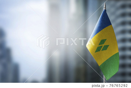 A small flag of Saint Vincent on the background of a blurred background A small flag of Saint Vincent on the background of a blurred background 76765292