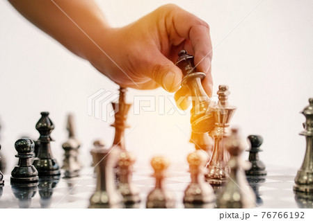 hand of businessman moving chess board game in competition success play 76766192