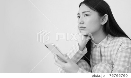パジャマ姿でスマートフォンを操作する女性イメージ 76766760