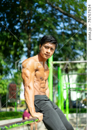 a naked Asian muscular man in a sitting pose and showing his muscular arms a naked Asian muscular man in a sitting pose and showing his muscular arms 76767634