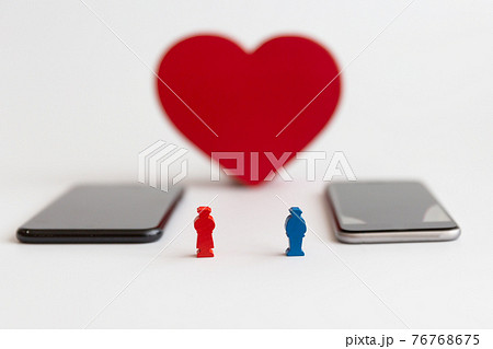 赤いハートと男女の人形、スマートフォン　LINE 婚活 マッチングアプリ 出会い 恋愛イメージ 76768675