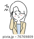 頭痛で頭を抑える女性 76769809