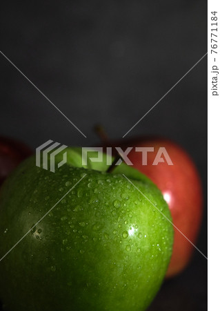 green and red apple on dark background green and red apple on dark background 76771184