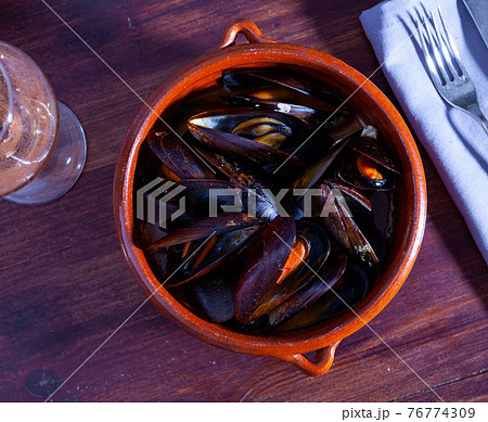 Clay bowl of stewed molluscs a la marinera 76774309