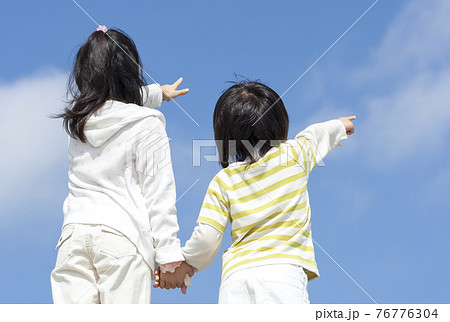 空を指差す女の子と男の子 76776304