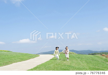 芝生を走る女の子と男の子 芝生を走る女の子と男の子 76776346