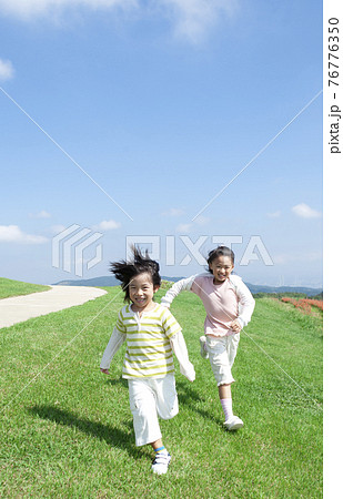 芝生を走る女の子と男の子 76776350