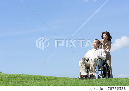車椅子で散歩するシニア夫婦 76776528