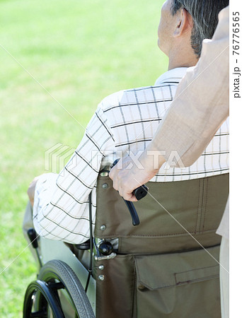 車椅子で散歩するシニア夫婦 76776565