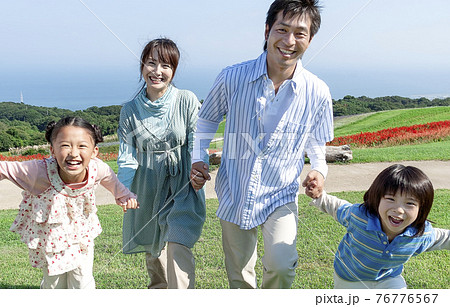 手を繋ぐ笑顔の家族 76776567