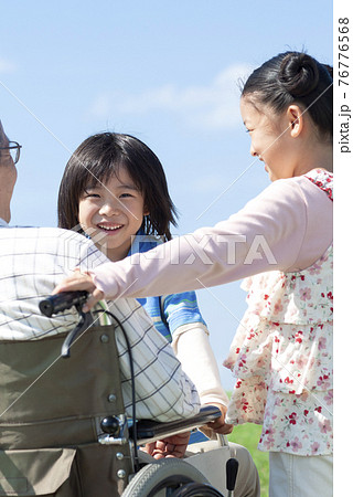 車椅子に座るシニア男性と孫 76776568