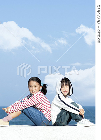 防波堤に座る女の子と男の子 防波堤に座る女の子と男の子 76776621