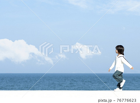 防波堤を歩く男の子の写真素材