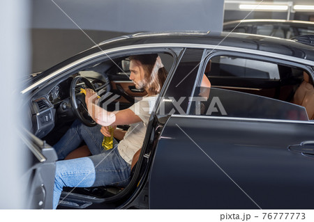 Man sitting in front seat of car cleaning Man sitting in front seat of car cleaning 76777773