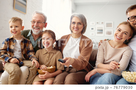 Happy big family watching TV and eating popcorn Happy big family watching TV and eating popcorn 76779030