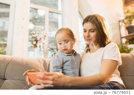 Family time. Mother and daughter having time together at home, look happy and sincere 76779051