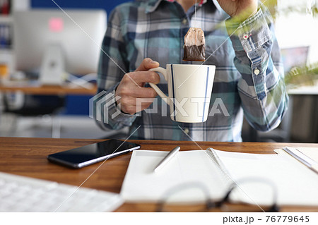 Woman putting tea bag into cup at table closeup 76779645
