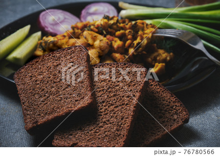 Chicken dish, black bread, onions and cucumbers on a dark background 76780566