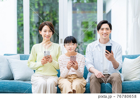 リビングでスマホを見るミドルの家族 リビングでスマホを見るミドルの家族 76780658