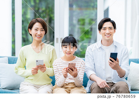 リビングでスマホを見るミドルの家族 リビングでスマホを見るミドルの家族 76780659